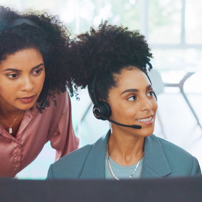 Business, women and call center with employee, manager and conversation for process, system and workplace. Female agents talking, headset and coworkers for customer support, telemarketing and support