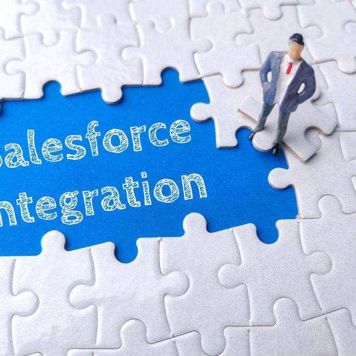 Miniature businessman on a white puzzle with text Salesforce Integration.